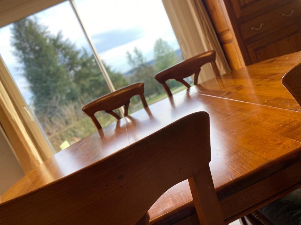 mesa de madera con 2 sillas y ventana grande en Quite House, en Villiers-le-Morhier