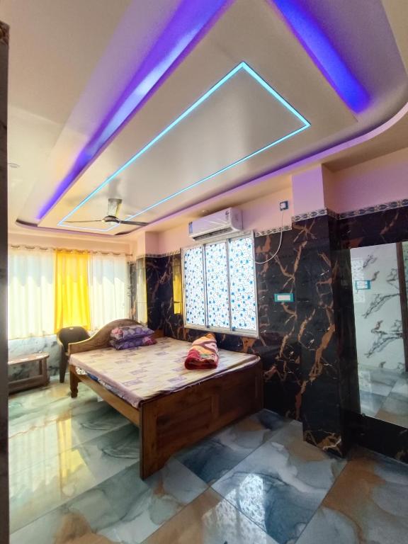 a bedroom with a bed in a room with purple lights at Mayapur Yatri Nivas in mayapur