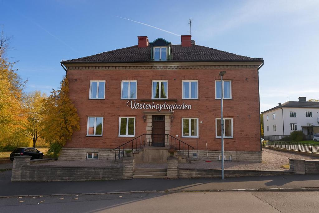 a large red brick building with a sign on it at Västerhöjdsgården in Skövde
