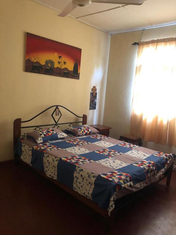 a bedroom with a bed with a quilt on it at Katys Lodge in Ja-Ela