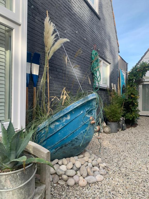 a blue boat sitting on the side of a house at Meerpaal 43 Bergen in Bergen