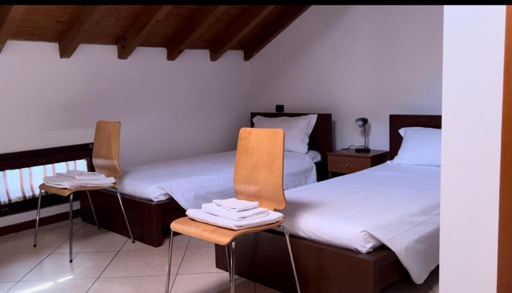 a room with two beds and a table and chairs at Residenza La Torre Pizzighettone in Pizzighettone
