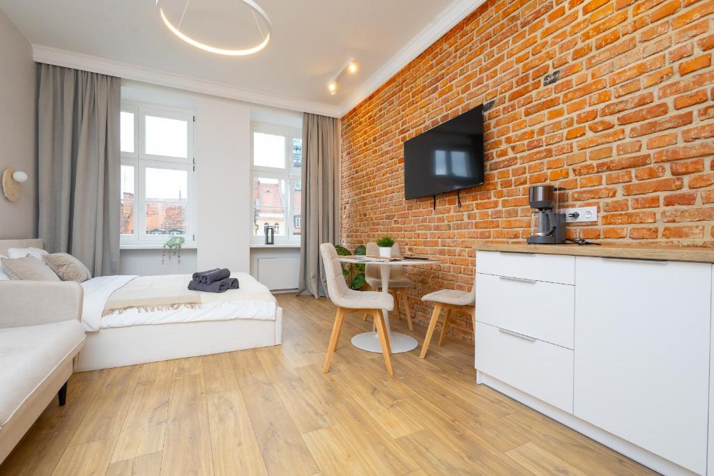 a bedroom with a brick wall and a bed and a table at Central Lux Apartment - Heart of the Old Town Check In 24h in Wrocław