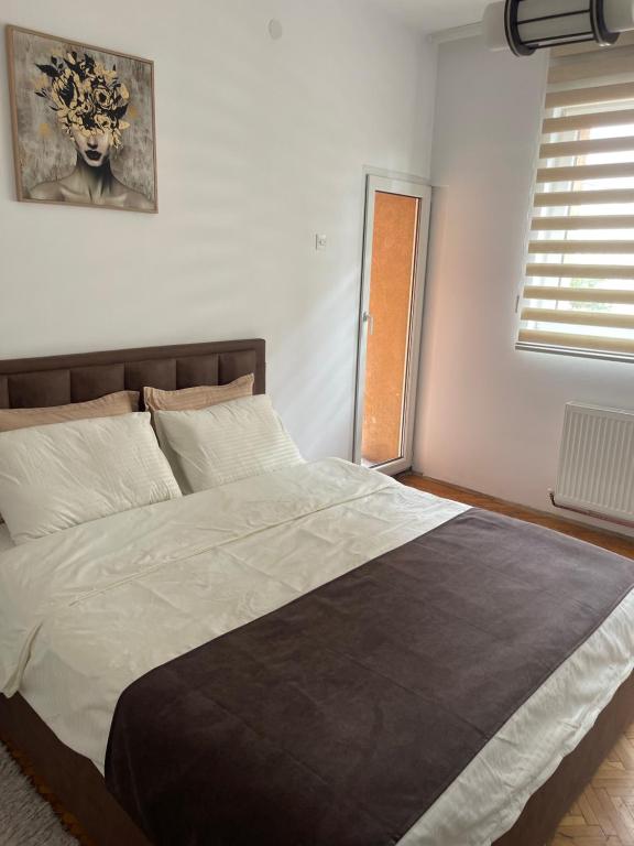 un dormitorio con una cama grande en una habitación en Comfy Downtown Apartment Prishtina, en Pristina