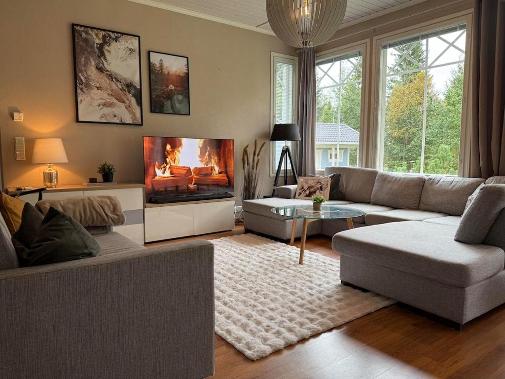 a living room with a couch and a fireplace at Rovaniemi Santas Home in Rovaniemi