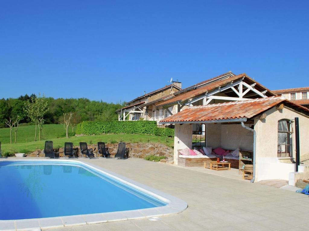 a swimming pool in front of a house at Lovely spacious cottage on a fine estate with a heated pool in Roussines