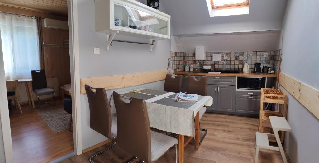 a kitchen with a table and chairs in a room at Barbara Ház in Hévíz