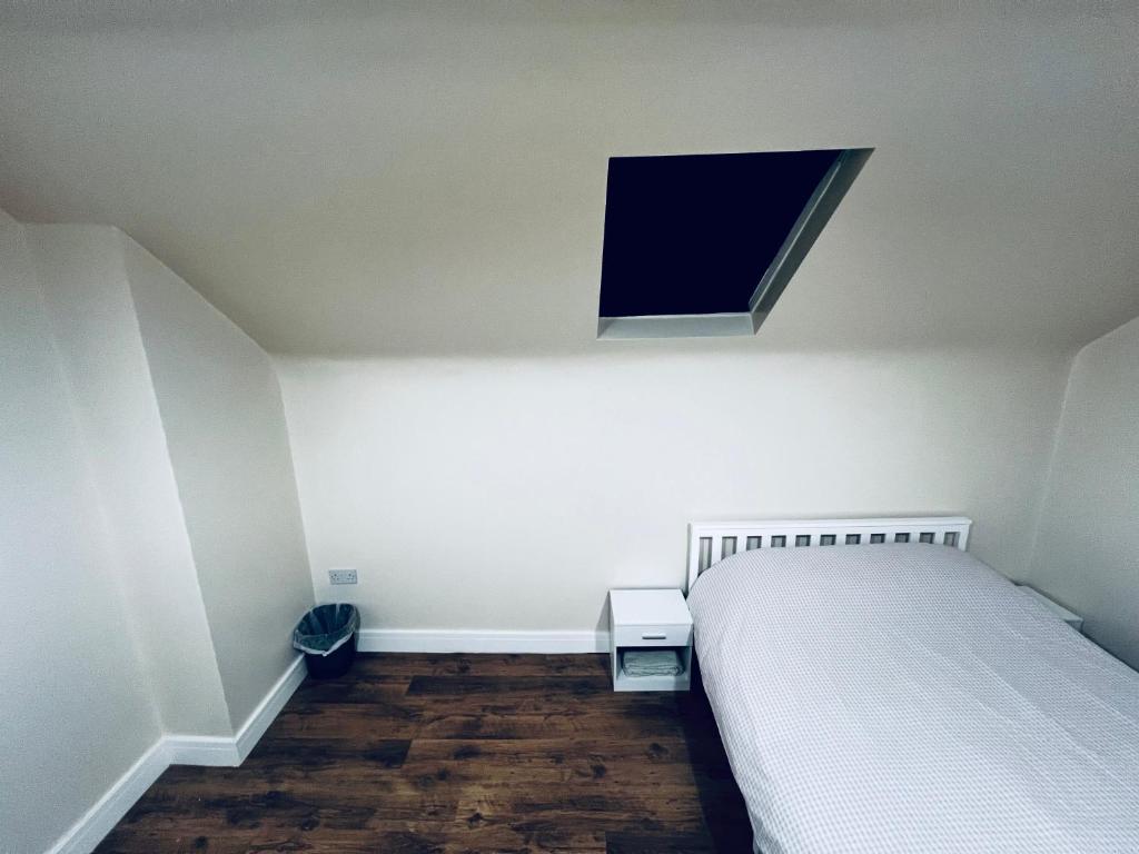 a bedroom with a bed and a tv on the wall at The Central Hub Luton B in Luton