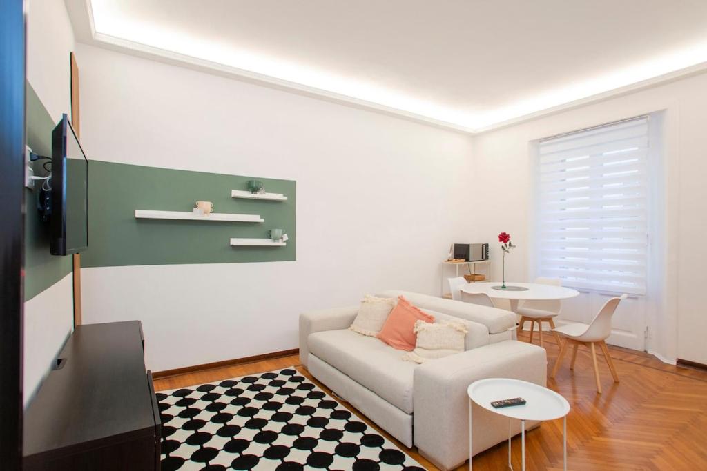 Una sala de estar con un sofá blanco y una mesa. en Monti 29 - Corso Sempione Milano, en Milán