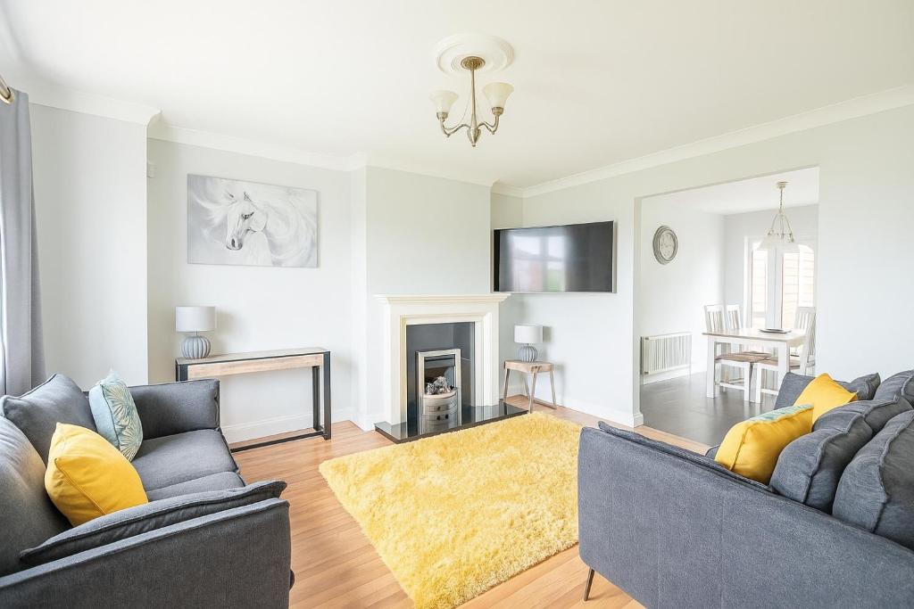 a living room with two couches and a fireplace at 3 Bed Spacious House in Golf Links Road 