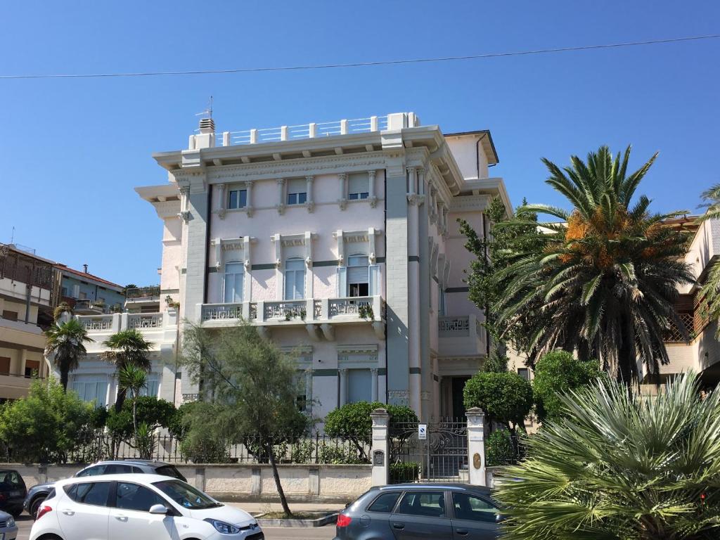 um edifício branco com carros estacionados em frente em Attico vista mare em Pescara