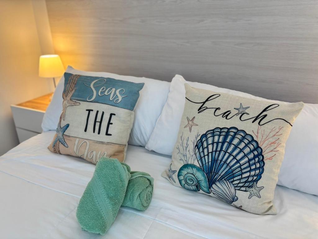 Una cama con almohadas con las palabras "salva la tierra" en Apartamento de descanso Om Shanti Om, en Coveñas