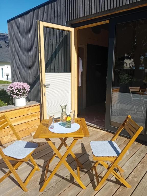 a picnic table and two chairs on a deck at XCUBE Tinyhouse in Bad Dürrheim