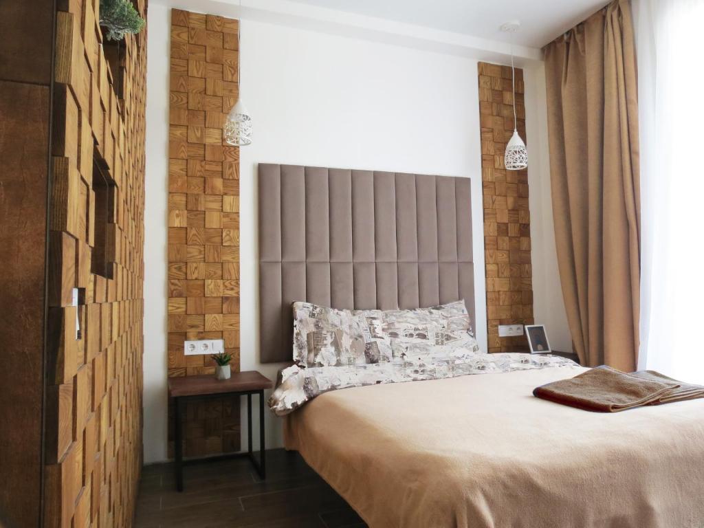 a bedroom with a large bed with a large headboard at Sweet Home in Kyiv