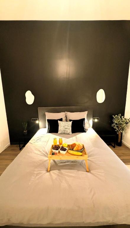 a large white bed with a tray of food on it at La Sucrerie - Charme Industriel RDC in Abbeville
