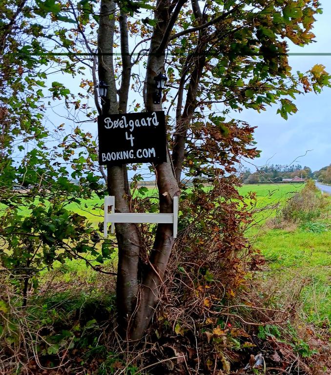 a sign on a tree in a field at Bøelgaarden in Gørding