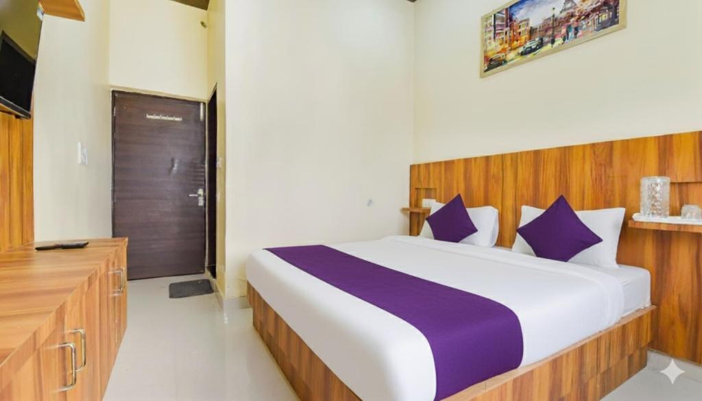 a bedroom with a large bed with purple pillows at 4Everstay By Shree Residency Luxury Rooms With Free Wifi & Free Parking in Vrindāvan