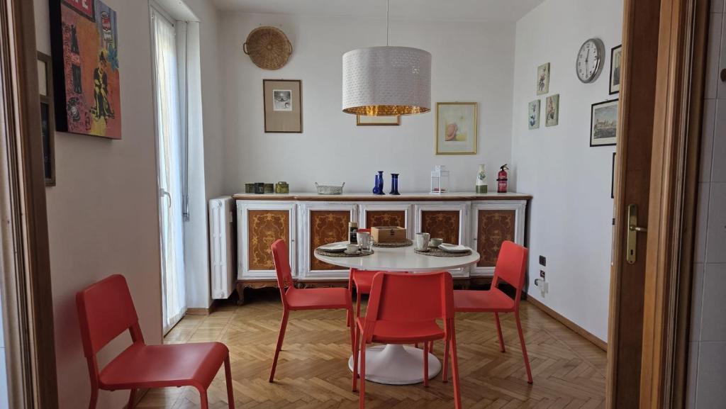 Un comedor con una mesa y sillas rojas. en Residenza Vernato, en Biella