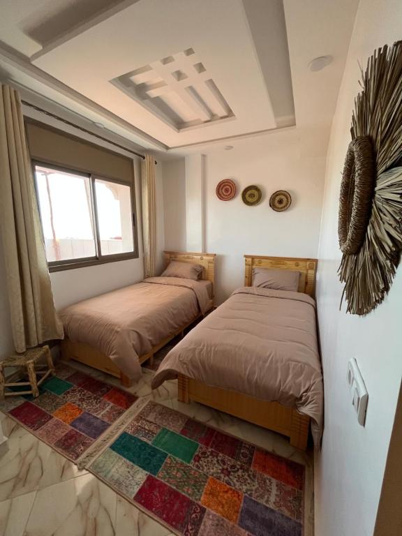 a bedroom with two beds and a window at Banana Surf Lodge & Surfcamp in Tamraght Ouzdar