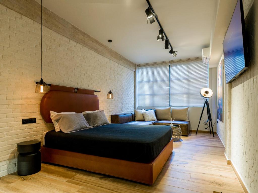 ein Schlafzimmer mit einem großen Bett und einer Couch in der Unterkunft Bee plus by CityBee in Athen