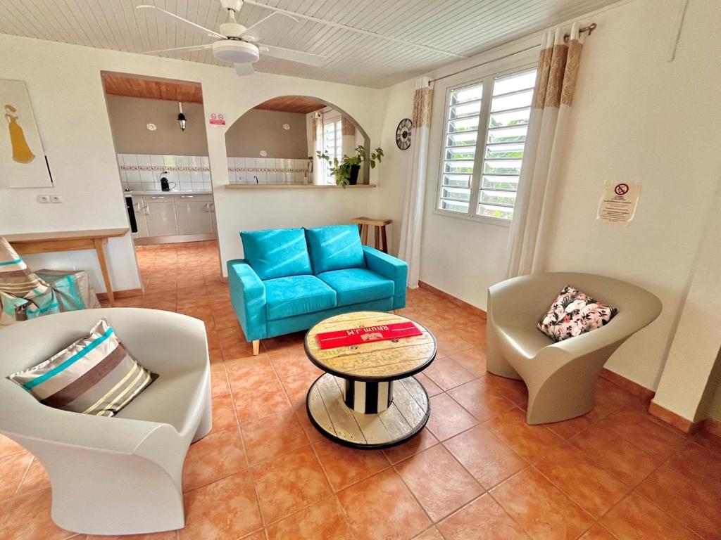 a living room with two chairs and a table at Charmant T3 en RDJ chez Ketty à Ducos in Ducos