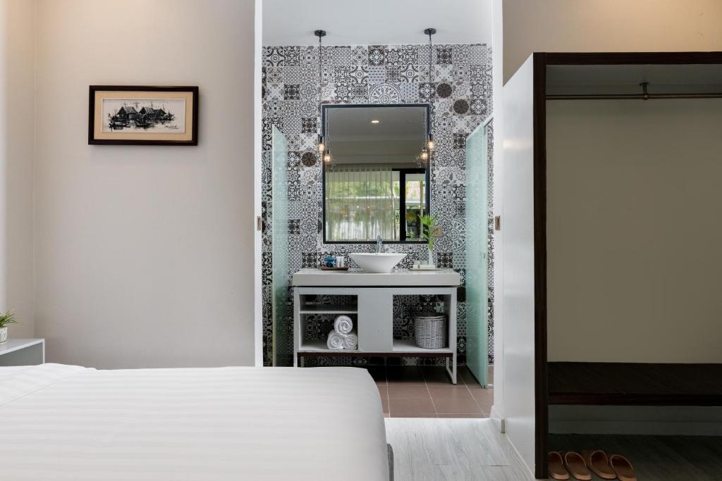 a bedroom with a sink and a mirror at The Peace House - Siem Reap in Phumĭ Sândăn