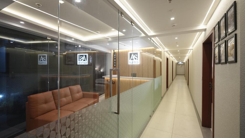 a hallway with a waiting room with a chair and signs at AS Suites in Cochin
