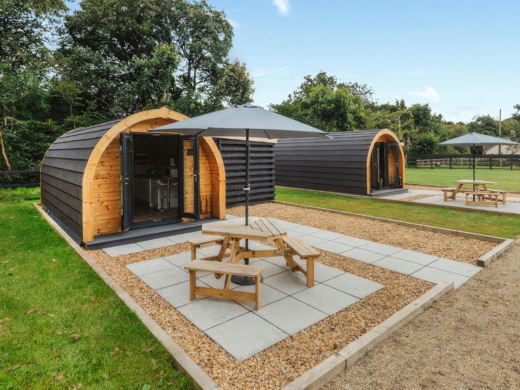 a wooden cabin with an umbrella and a picnic table at Islay - Uk48416 in Dalry