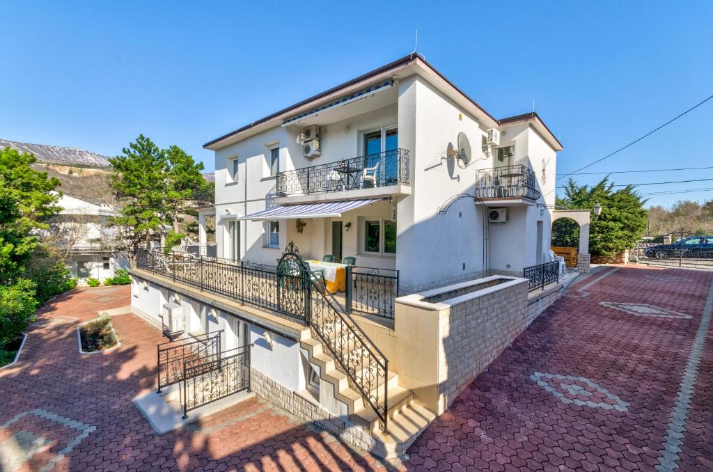 a white house with balconies on a street at Seaside Villa by JR City Apartments in Jadranovo