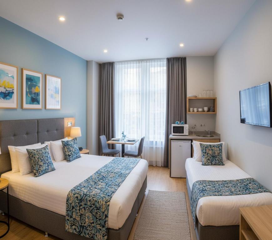 una habitación de hotel con dos camas y una mesa en Redone House, en Alejandreta