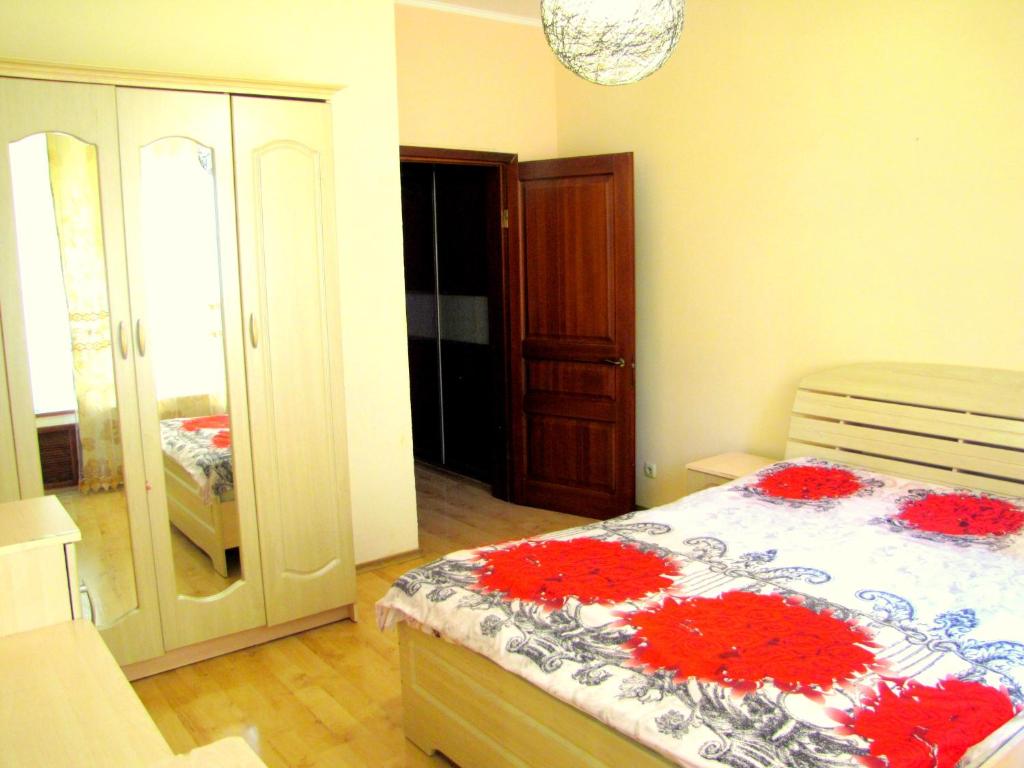 Un dormitorio con una cama con flores rojas. en Guest House On Abdulliny Street 54 en Almaty