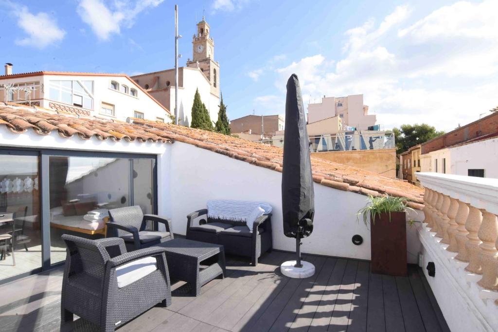 a patio with chairs and a umbrella on a roof at Marina Vila House, Vista Playa in El Masnou