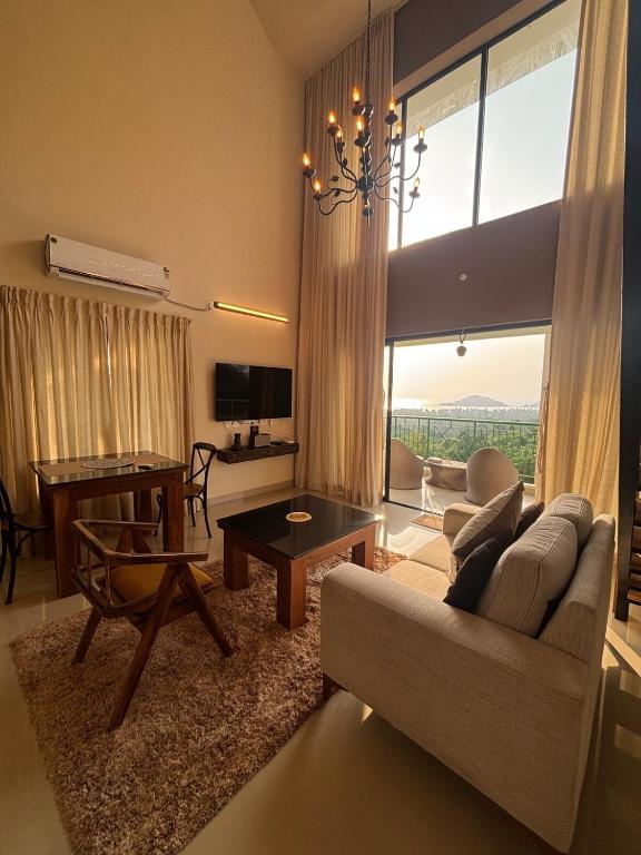 a living room with a couch and a table at Saanjh-Kudrats Nilaya in Canacona