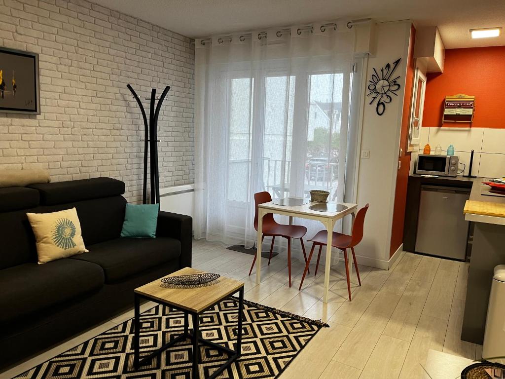 a living room with a couch and a table at Studio " escale en bord de mer " in Wimereux