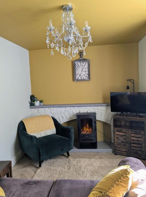 a living room with a chandelier and a fireplace at 7 dodds lane alnwick in Alnwick