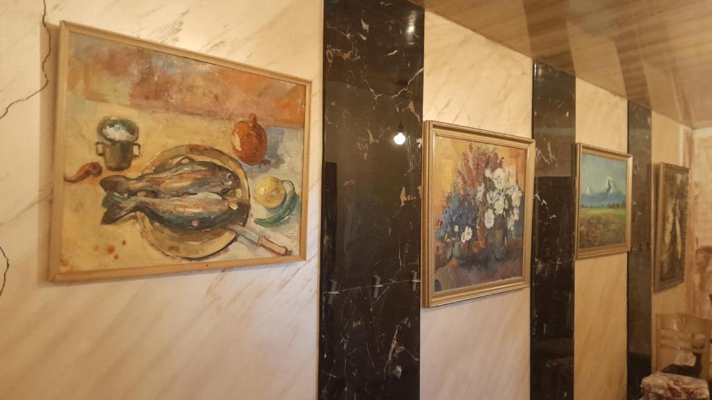 a wall with three paintings on it at Агарод in Atʼarbekyan