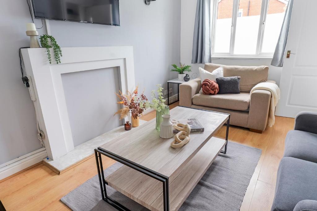 a living room with a coffee table and a fireplace at Haydock Home with FREE Parking, WiFi & Garden Patio in Haydock