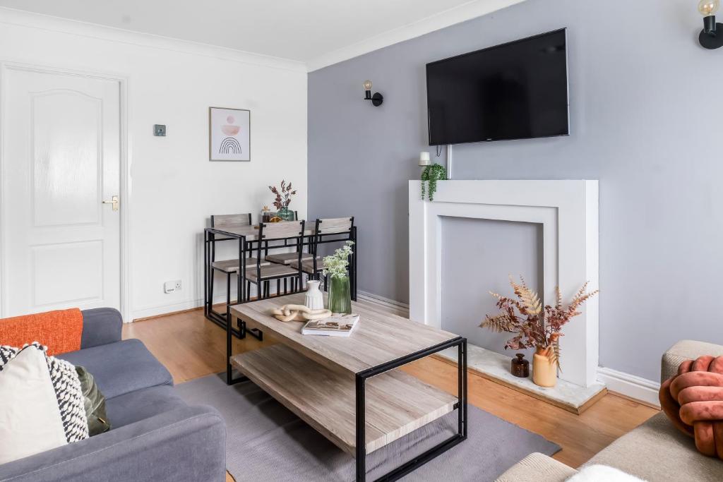 a living room with a table and a fireplace at Modern House in Haydock with FREE Parking & Garden Patio in Haydock