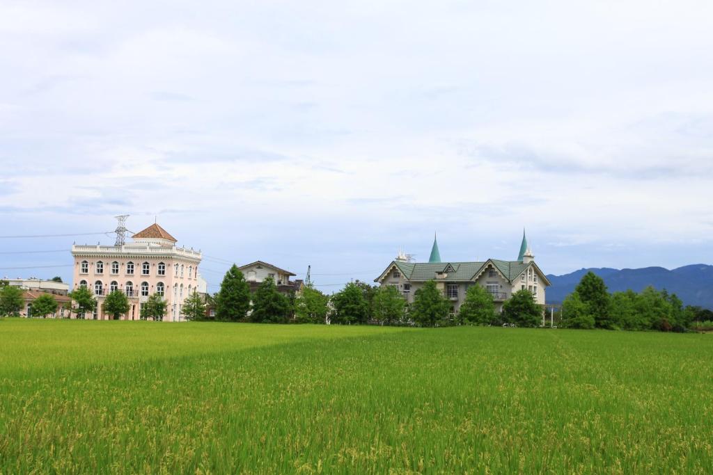 a large grass field in front of a building at Sigma Castle in Yuanshan