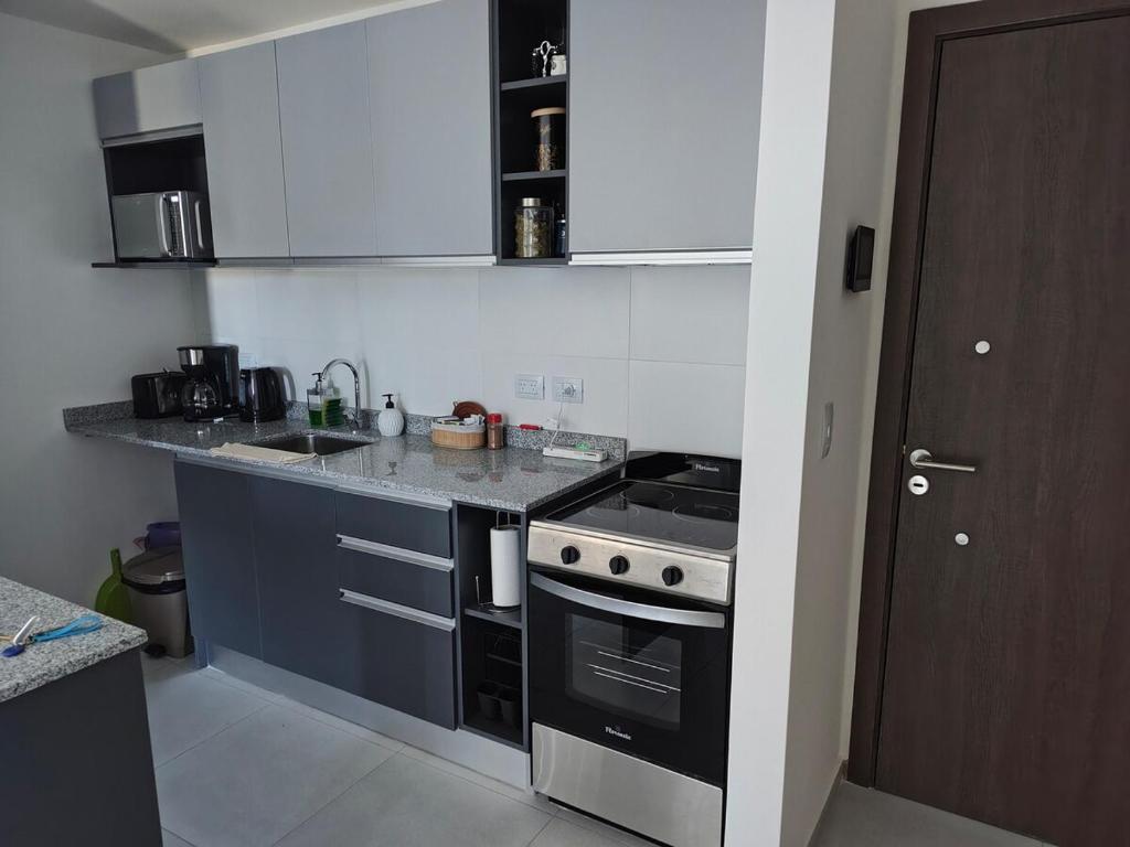 a kitchen with blue cabinets and a stove top oven at Arévalo - D2 in Cipolletti