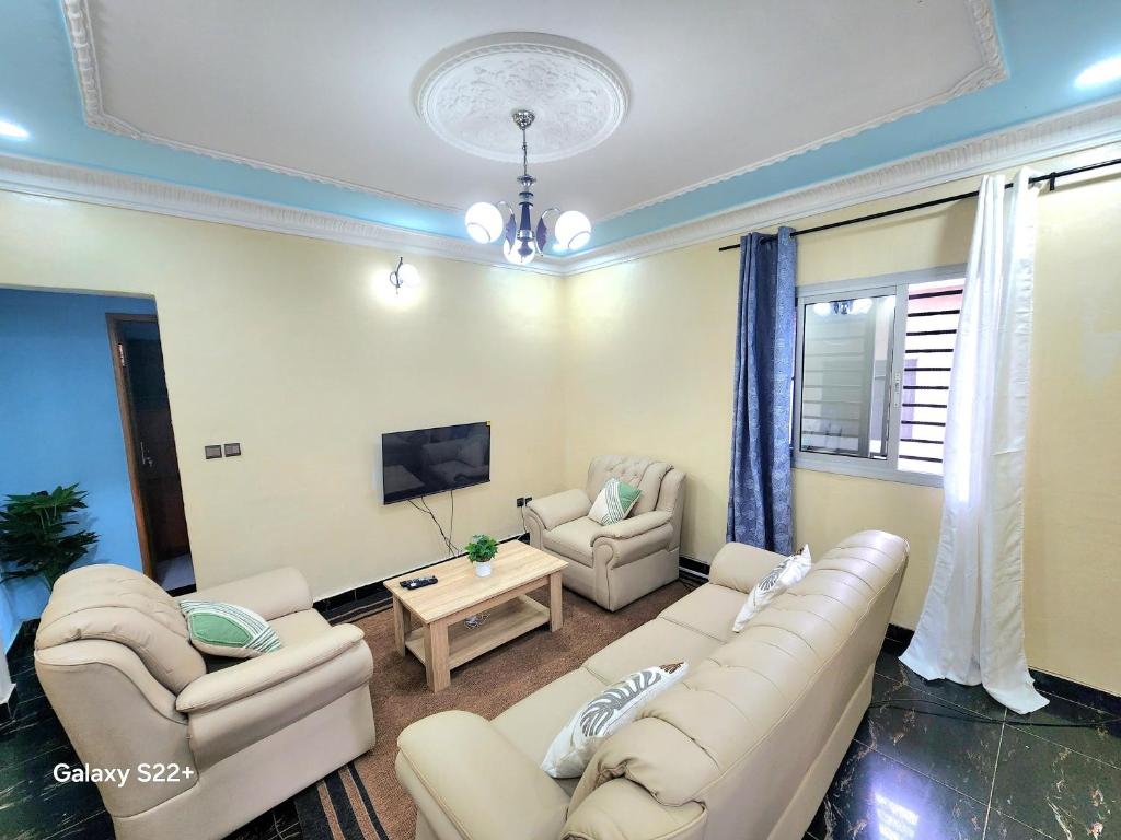 ヤウンデにあるClimatisation - Wi-Fi gratuitのリビングルーム(ソファ、テレビ付)