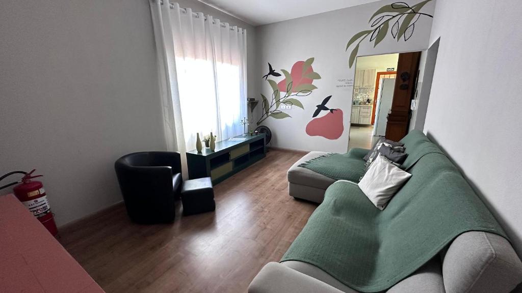 a living room with a green couch and a chair at Quartos Villa do Aconchego Casa compartilhada in São João da Boa Vista