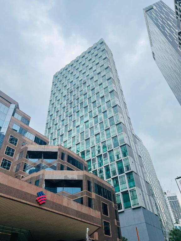 a tall glass building in the middle of a city at Soho Star Suites near by Klcc in Kuala Lumpur