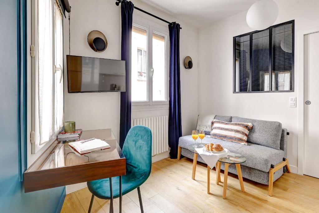 a living room with a couch and a table at Le Marais & Place des Vosges - Paris Vacation Rentals in Paris