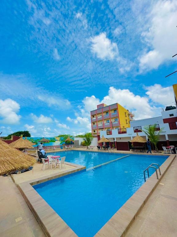 a large blue swimming pool with a building in the background at Teranga Sénégal Chez Mimi in Toubab Dialaw