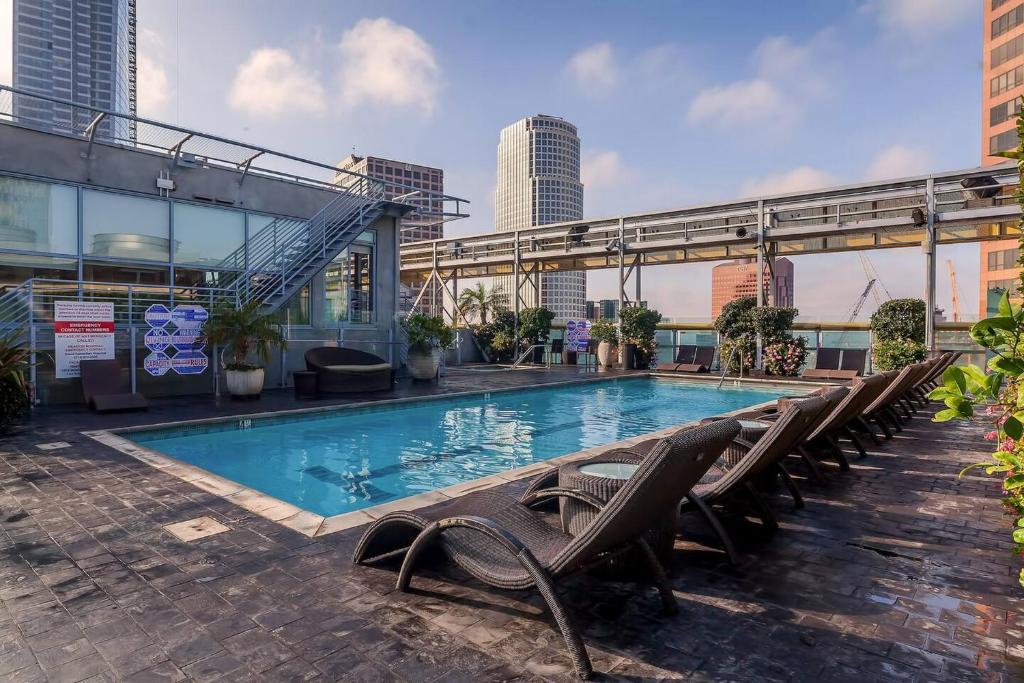 a swimming pool with lounge chairs and a building at Stylish 2BR Loft with Top-Tier Amenities - 104 - GL in Glendale