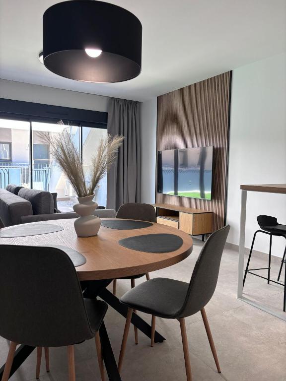 a living room with a dining room table and chairs at Premium Alicante in Gran Alacant