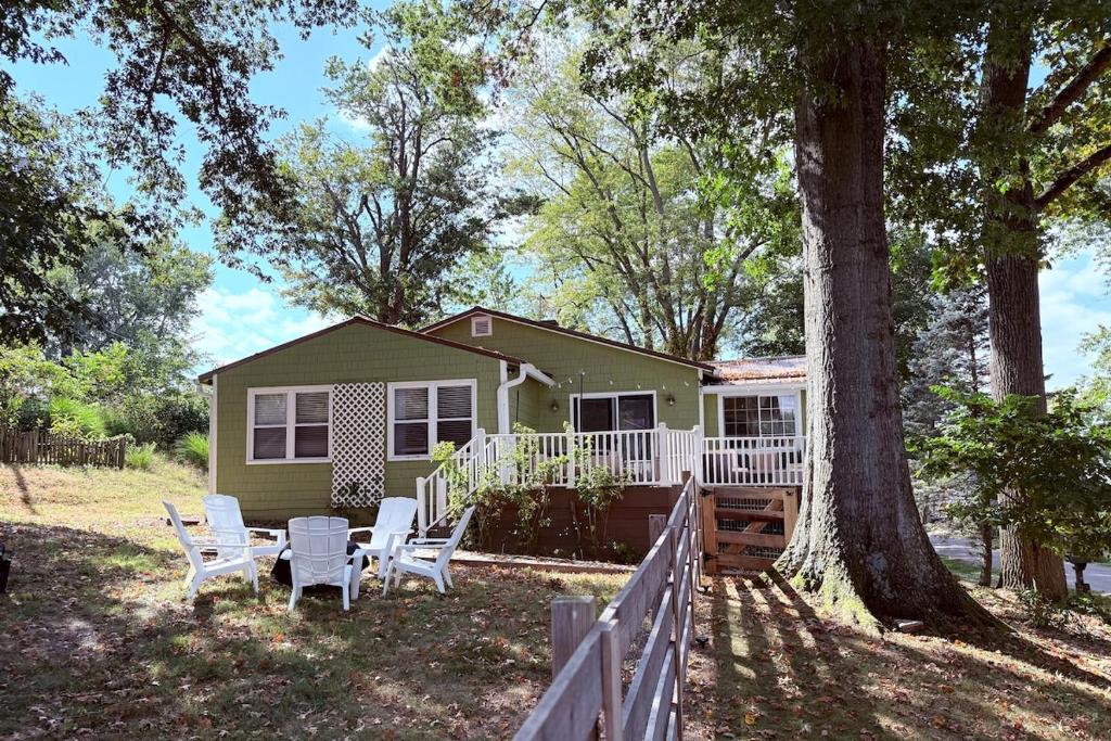 a small house with white chairs and a tree at The Float House at Buckeye Lake - Hot Tub - Patio - Privacy in Thornville