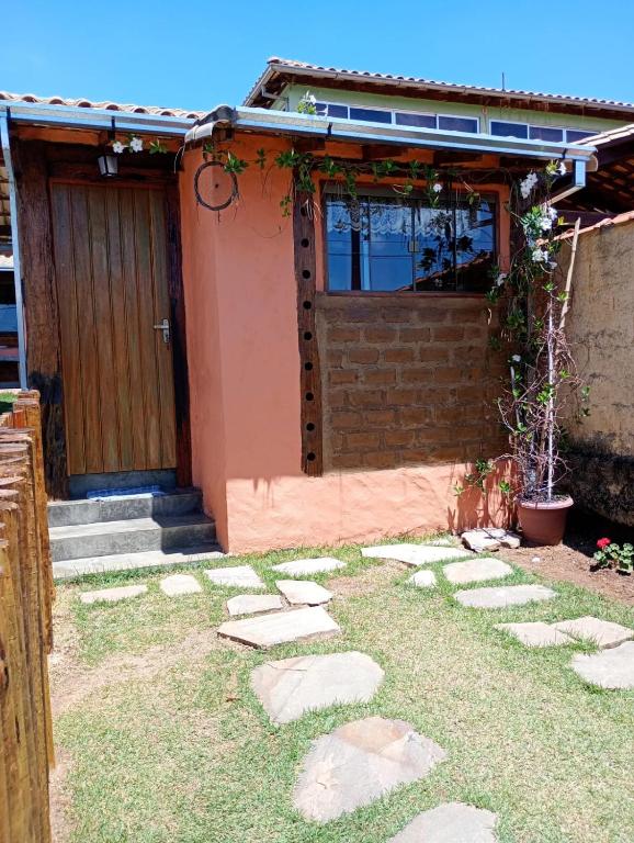 a house with a door and some rocks in front of it at CHALEZINHO Da LÚ in Carrancas
