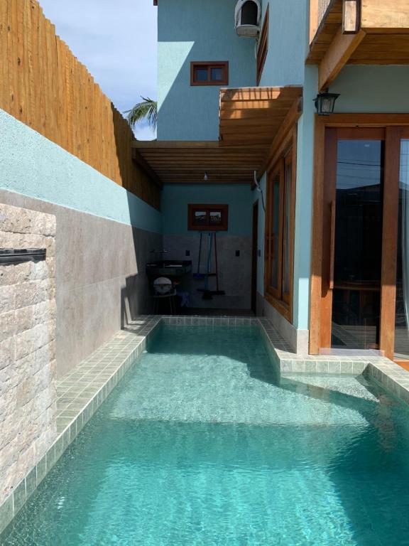 a swimming pool in the side of a house at Marlim-azul Loft in Prado